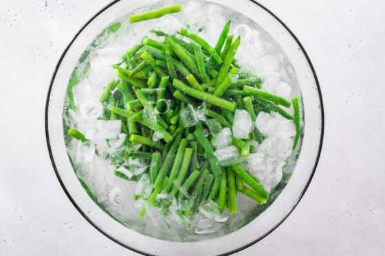 Green beans blanching in an ice bath.