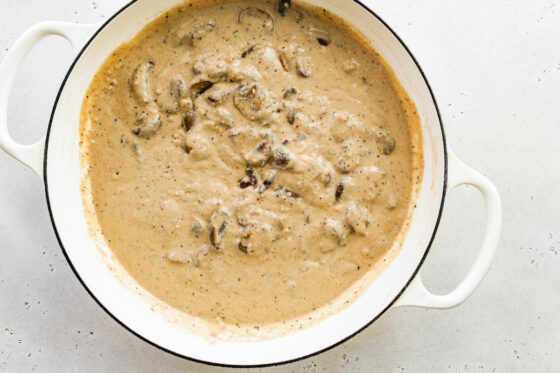 Cashew cream and mushrooms in a sauté pan.