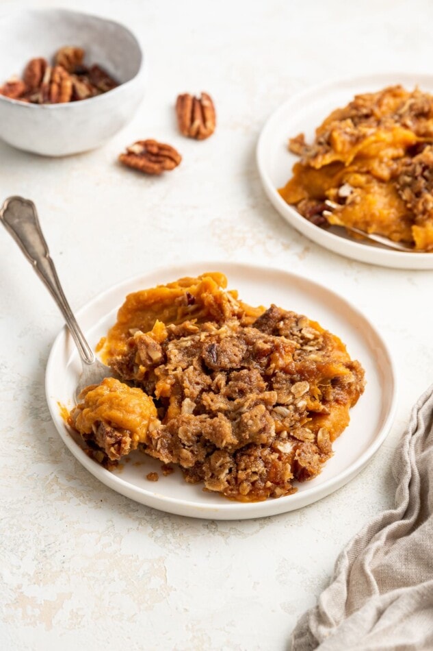 A portion of sweet potato casserole on a plate with a fork.