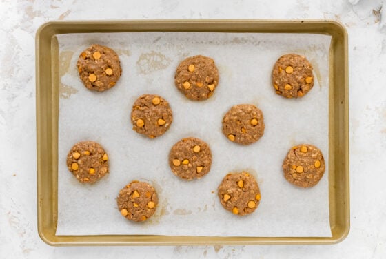 Ten baked cookies on a baking sheet lined with parchment paper.