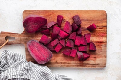 Beets chopped into even chunks on a cutting board.