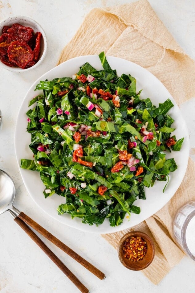 A serving bowl containing raw collard greens salad.