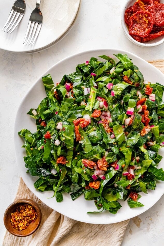 A serving bowl containing raw collard greens salad.