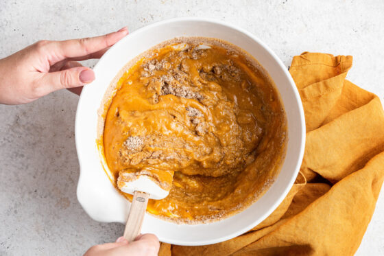 Incorporating the dry ingredients into the wet ingredients with a spatula.