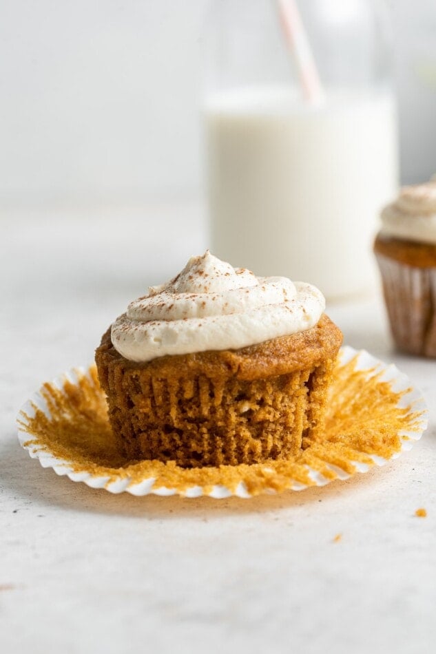 An unwrapped sweet potato cupcake with frosting.