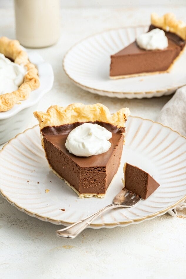 A slice of vegan chocolate pie on a plate with a fork ready with a bite.