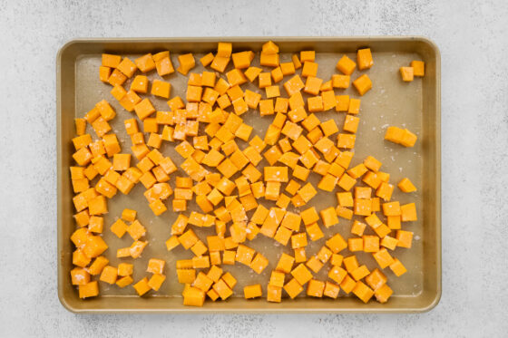 Cubed butternut squash on a baking sheet.