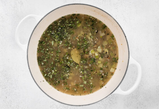 Wild rice simmering in water in a pot.