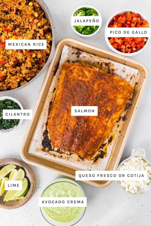 Ingredients out to make a Salmon Burrito Bowl: Mexican rice, jalapeno, pico de gallo, cilantro, salmon, lime, avocado crema and queso fresco.