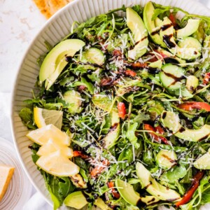 Bella Hadid's Salad in a serving bowl with lemon wedges.