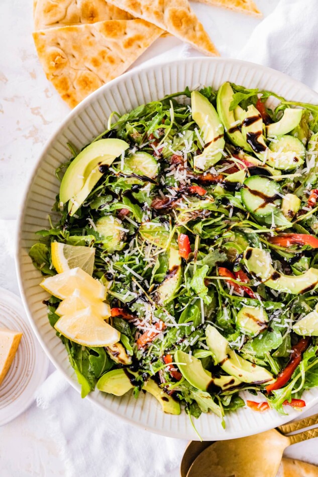 Bella Hadid's Salad in a serving bowl with lemon wedges.