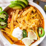 A bowl of chicken tortilla soup with toppings.