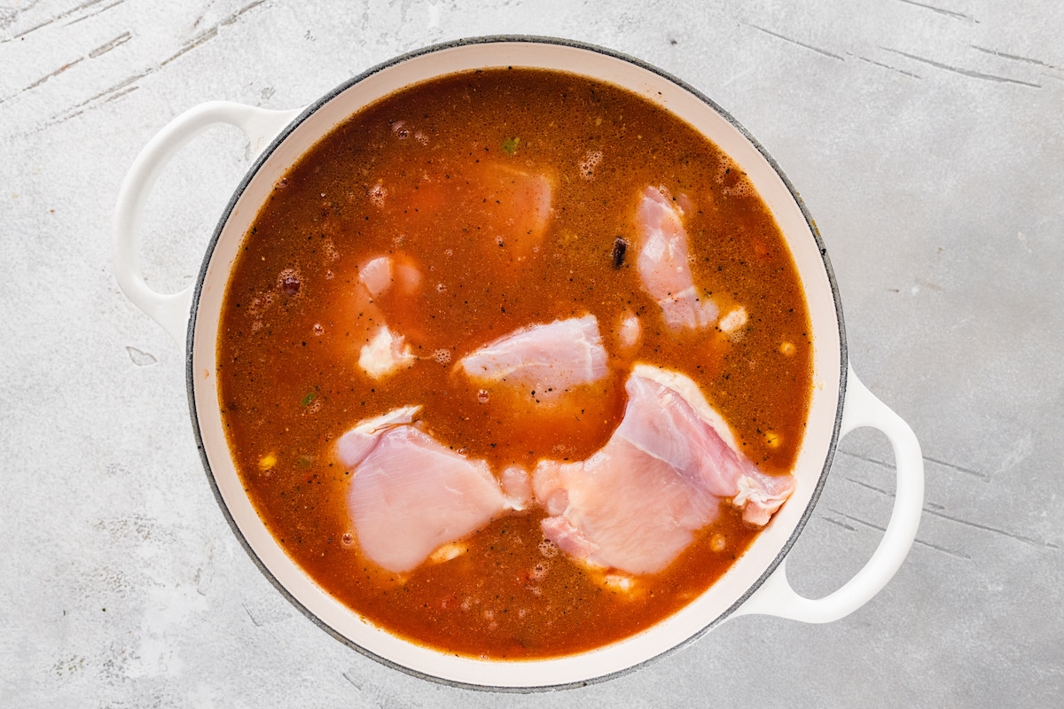 Chicken simmering in soup.