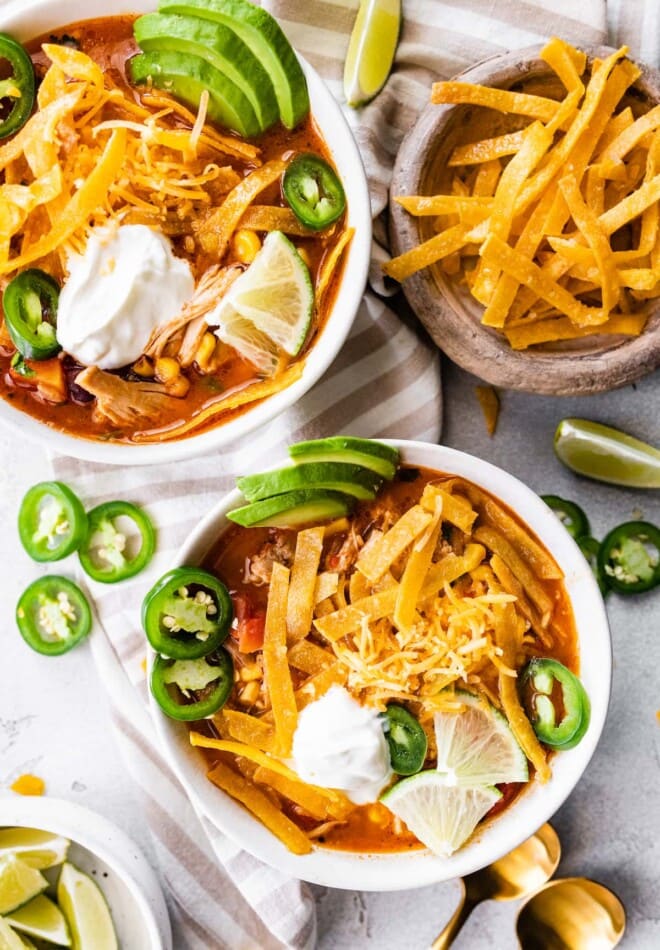 Bowls of chicken tortilla soup with extra tortillas.