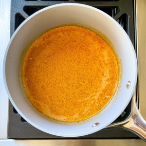 Coconut curry SunButter sauce cooking in a sauce pan.