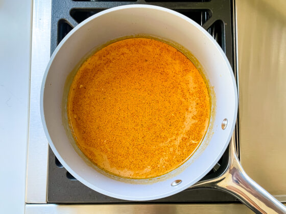 Coconut curry SunButter sauce cooking in a sauce pan.