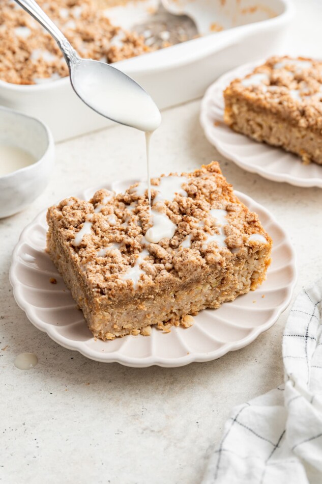 Drizzling extra coconut butter onto a square serving of coffee cake baked oatmeal.