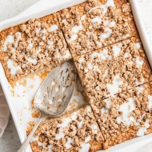 Portioned squares of coffee cake baked oatmeal in a baking dish, a square serving has been removed.