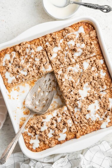 Portioned squares of coffee cake baked oatmeal in a baking dish, a square serving has been removed.