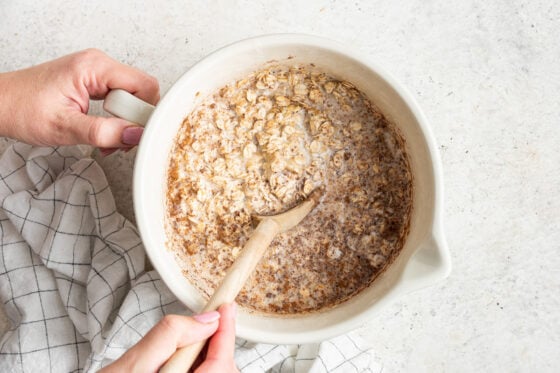 Mixing oatmeal ingredients in a bowl with a wooden spoon.