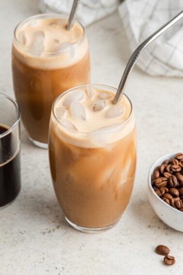 Two glasses with straws containing protein coffee.