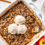 A healthy apple crisp topped with three scoops of ice cream.