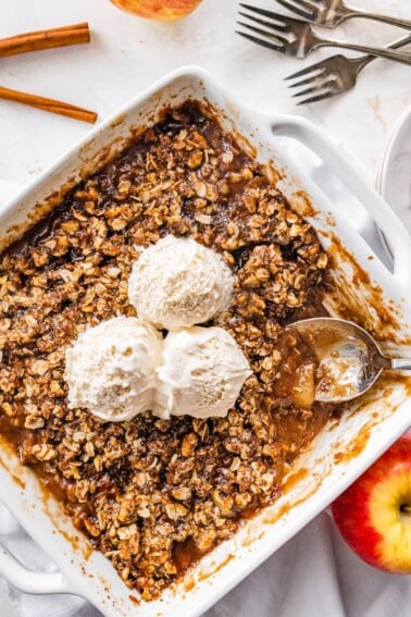 A healthy apple crisp topped with three scoops of ice cream.