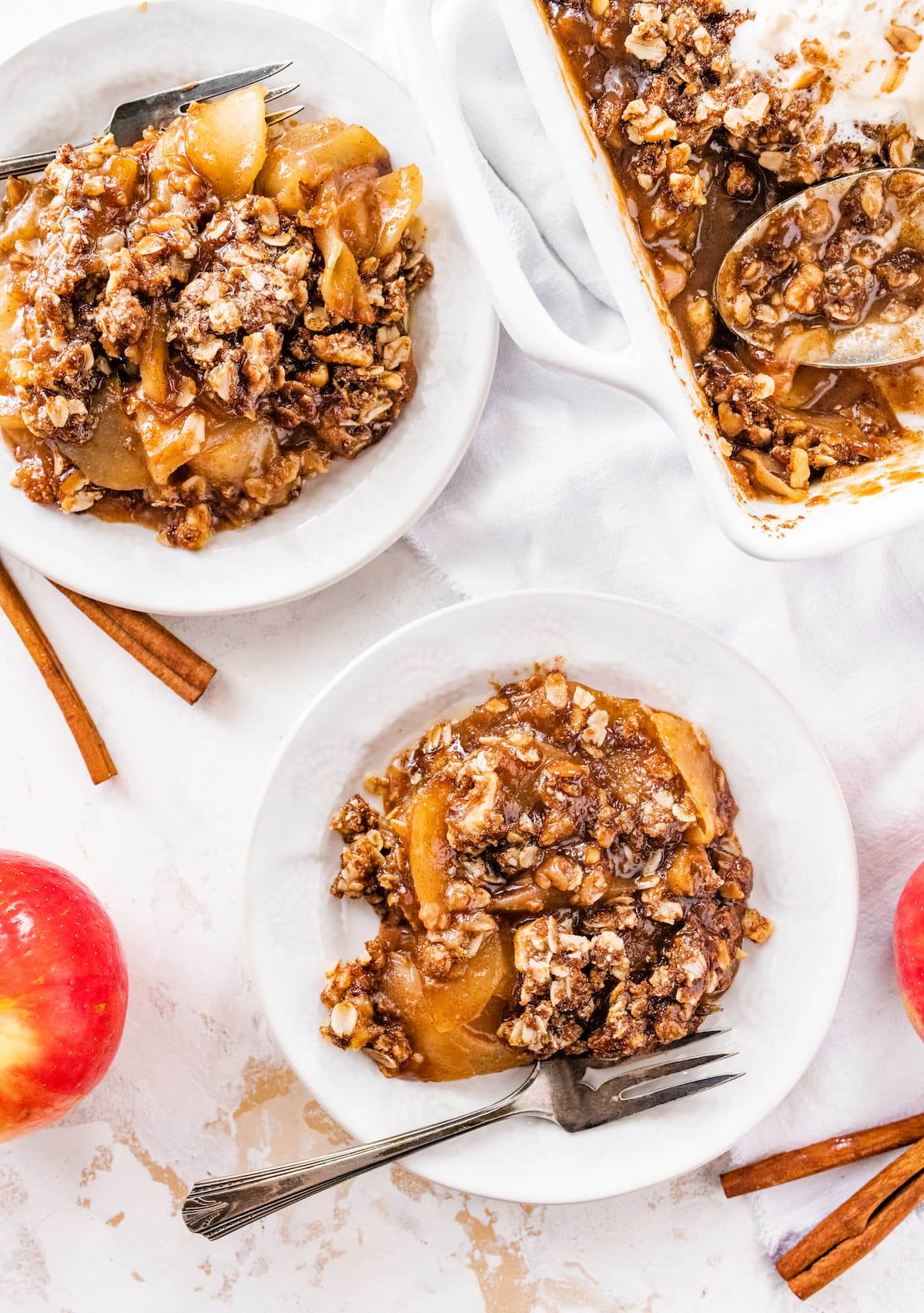 Two servings of apple crisp with forks.