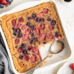 Quinoa breakfast bake in a baking dish with a serving spoon.