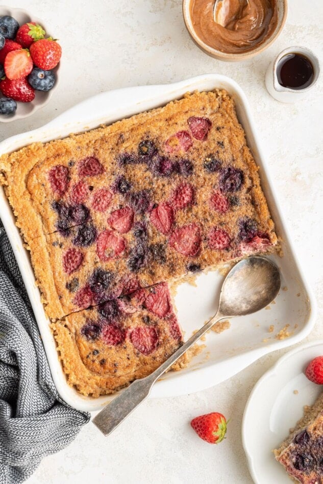 Quinoa breakfast bake in a baking dish with a serving spoon.