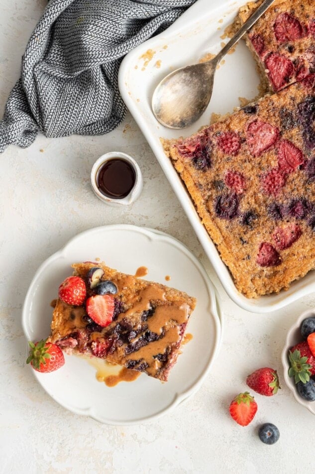A serving of quinoa breakfast bake on a plate next to a baking dish.