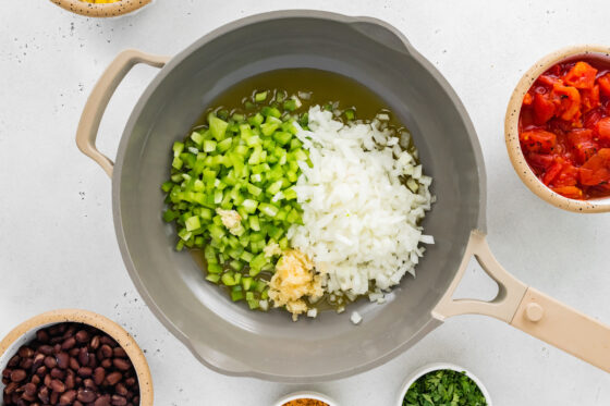 Green pepper, onion and garlic cooking in oil.