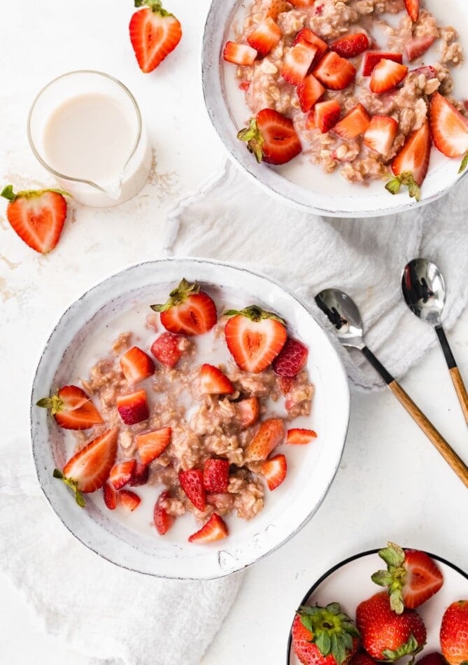 Two bowls of strawberries and cream oatmeal.