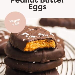 Stack of homemade peanut butter eggs. The top one has a bite taken out of it.