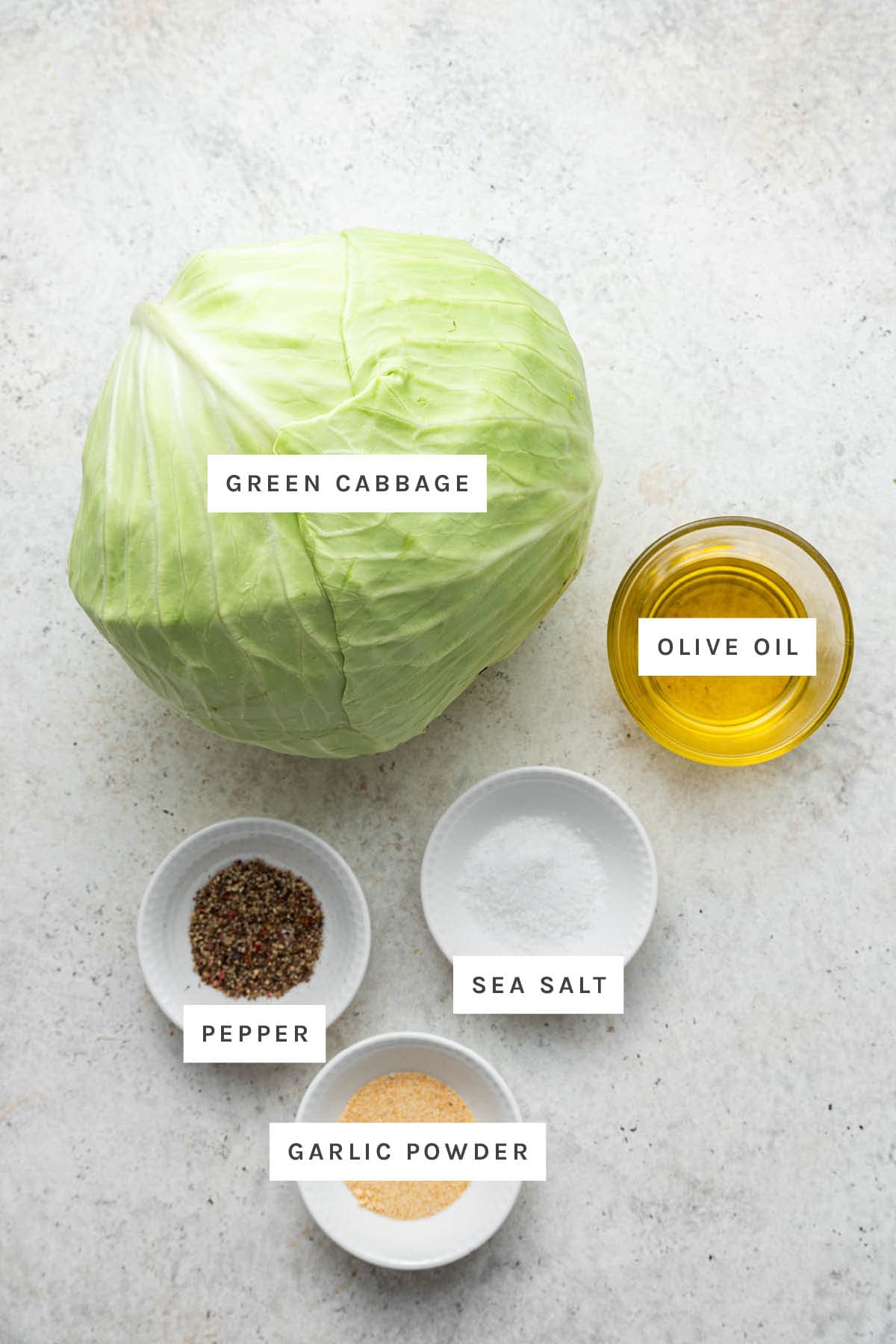 Ingredients measured out to make Roasted Cabbage: green cabbage, olive oil, pepper, sea salt and garlic.