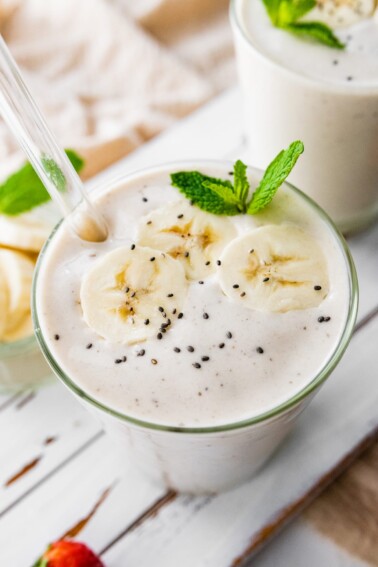 Banana protein shake with a straw.