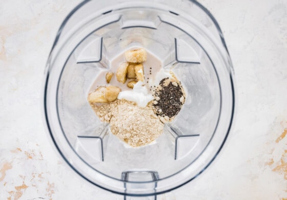 Ingredients for banana protein shake in a high powered blender.