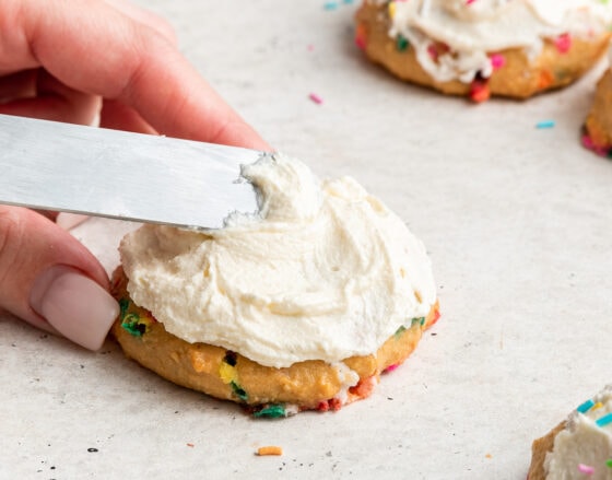 Icing a birthday cake cookie.