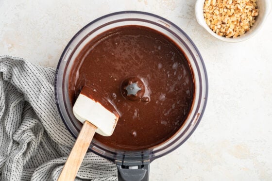 Mixing chocolate chips into brownie batter.