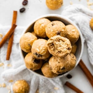 A bowl of protein balls, one of the balls has a bite taken out of it.