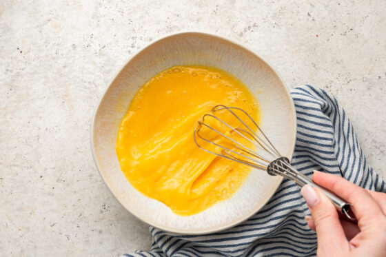 Two eggs whisked in a bowl.