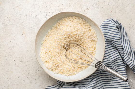 A bowl of breadcrumbs and shredded coconut.
