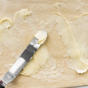 Smearing butter across a rectangle of dough.