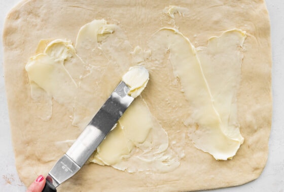 Smearing butter across a rectangle of dough.