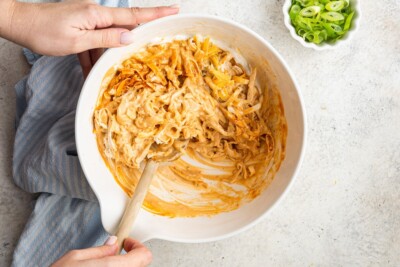 Chicken and ingredients mixed together in a bowl.