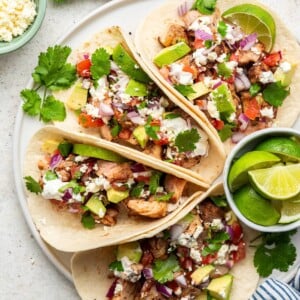 Chicken tacos arranged on a plate.