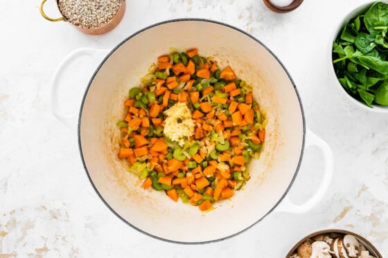 Celery, carrots and onion cooking in a pot with garlic.