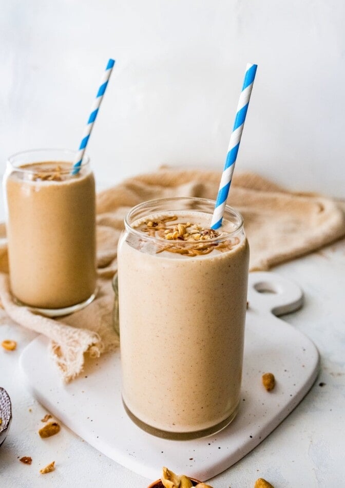 Two peanut butter protein shakes with straws.