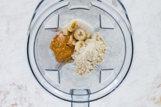 Ingredients for a peanut butter protein shake in a high powered blender.