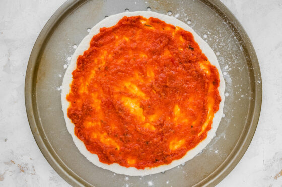 Pizza sauce coating pizza dough.